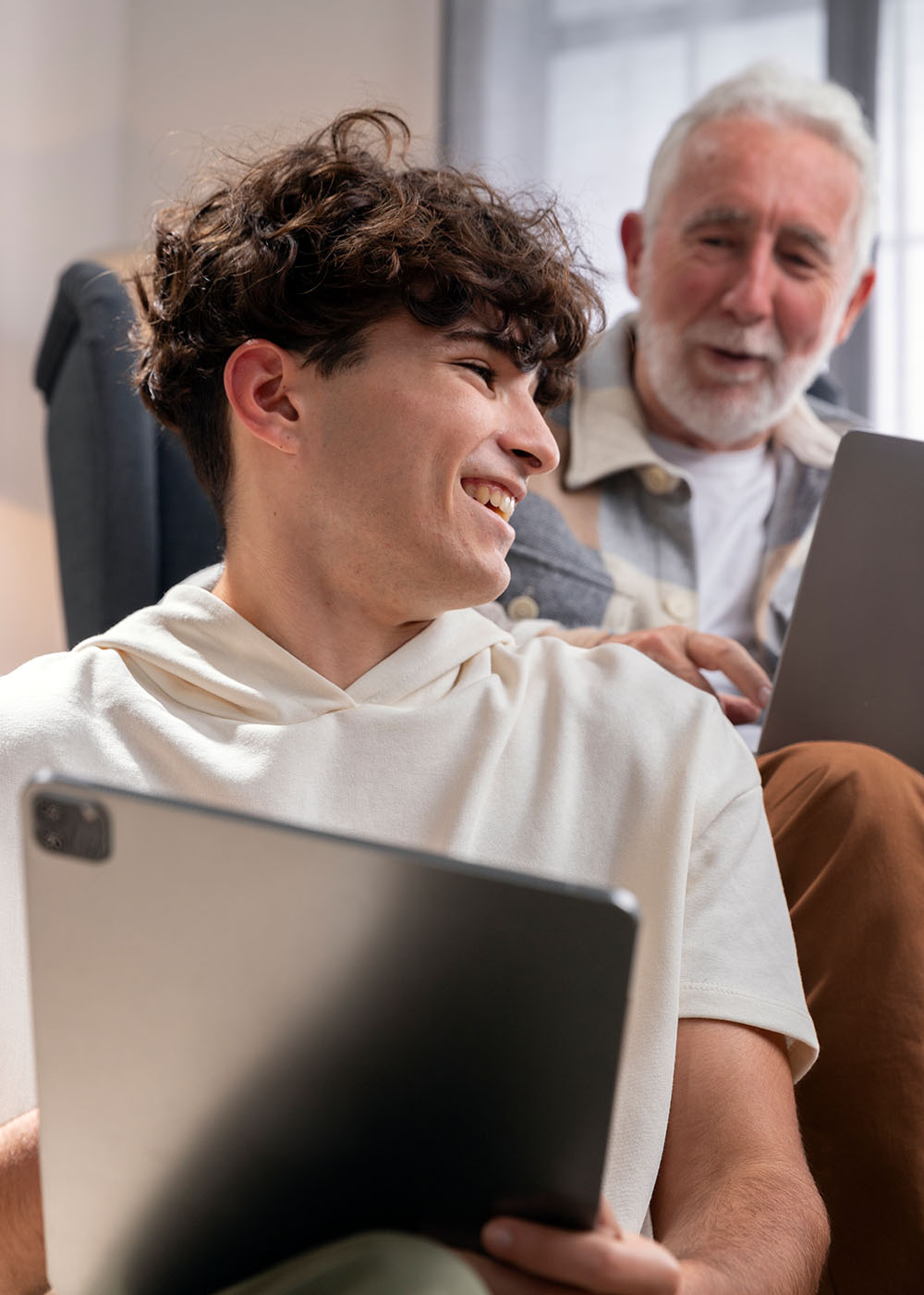 Medium shot grandparent and teen with devices