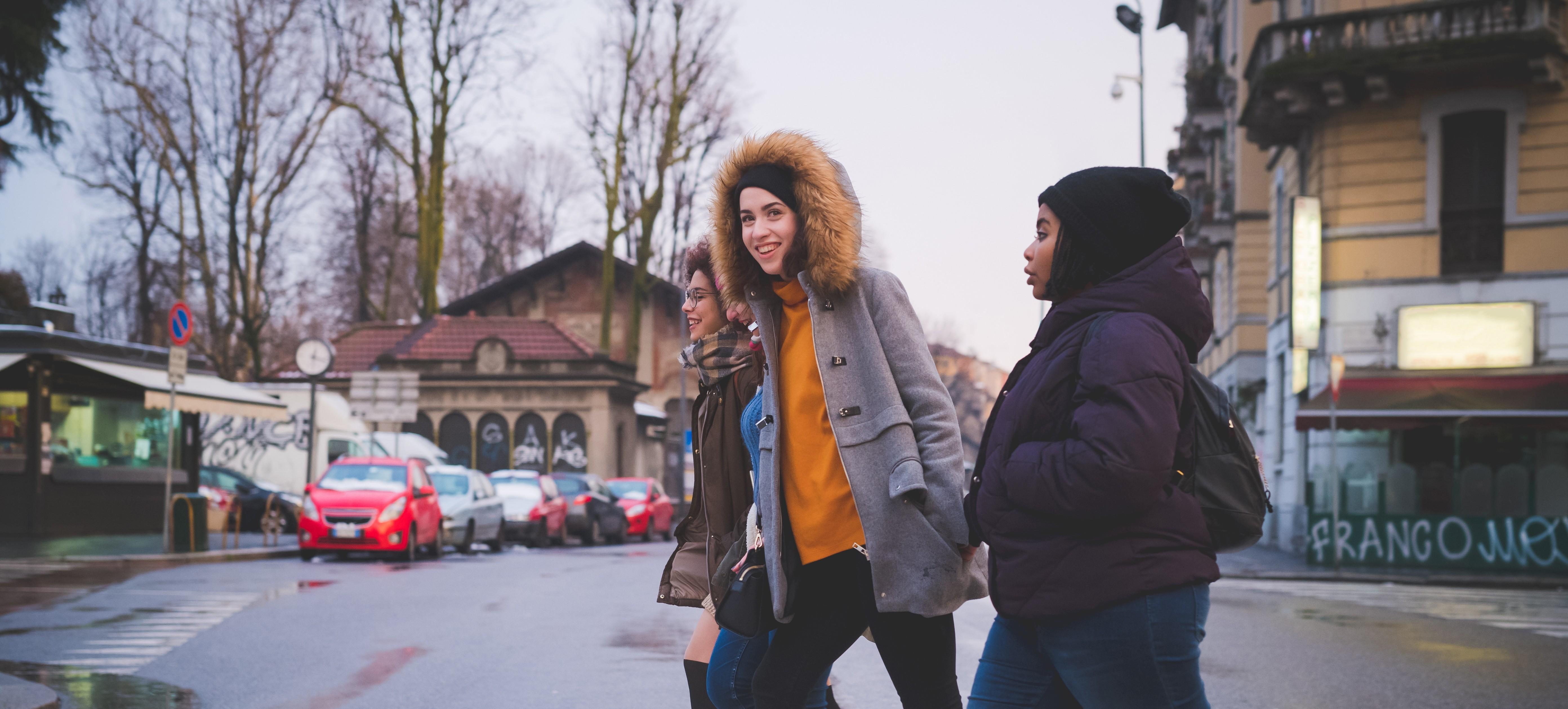 Three teenagers crossing the road together